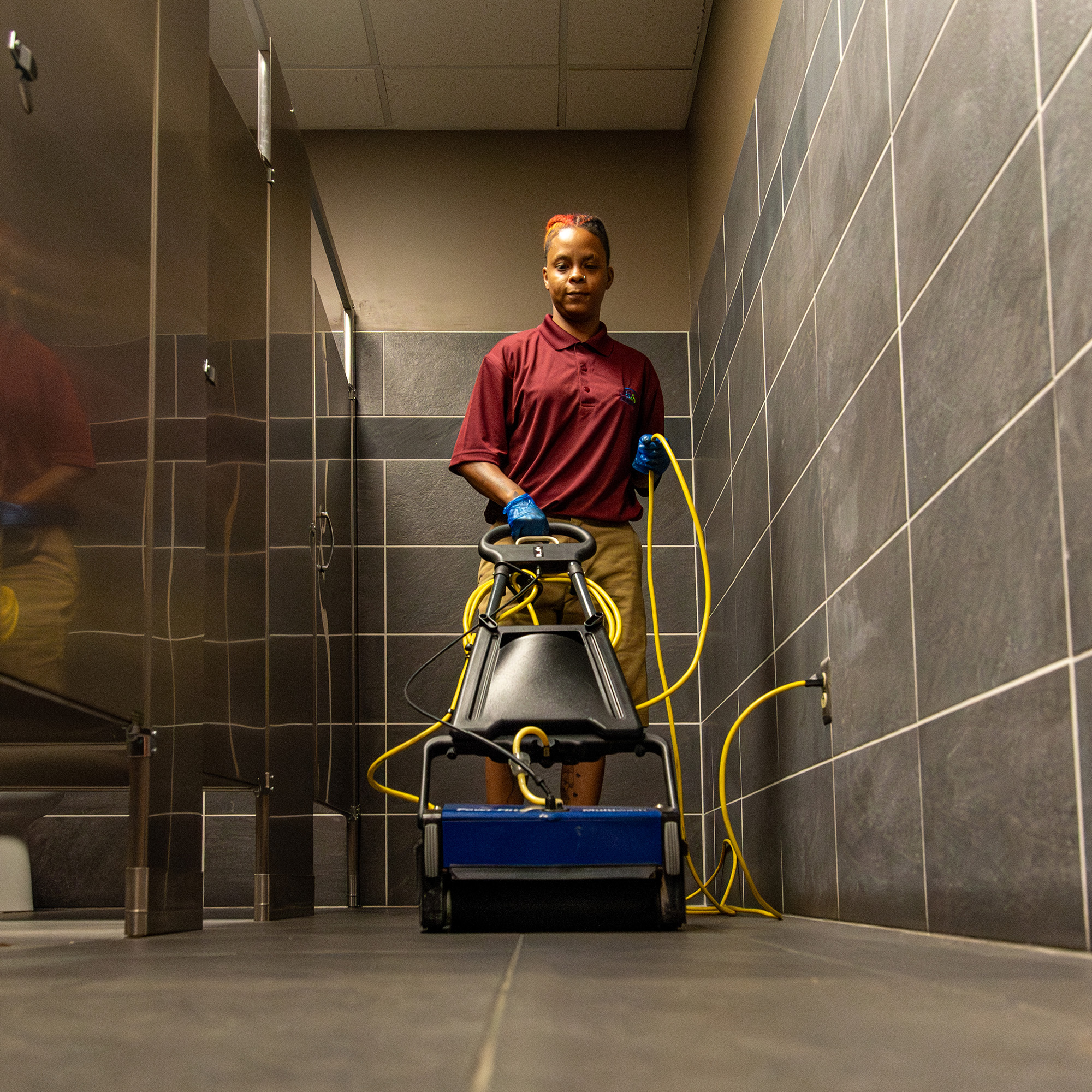 Floor care technician operating a scrubber