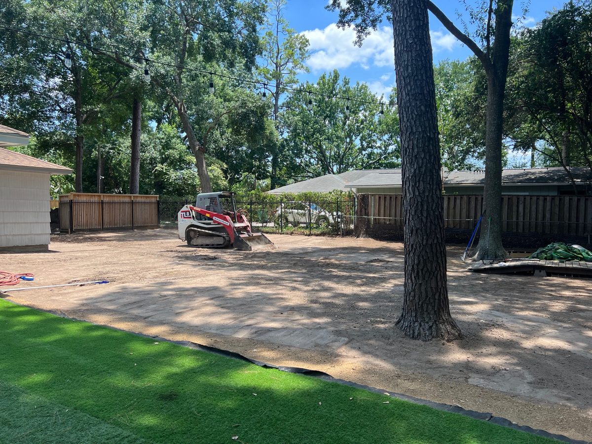 Skid-steer preparing the sub-base for a turf install